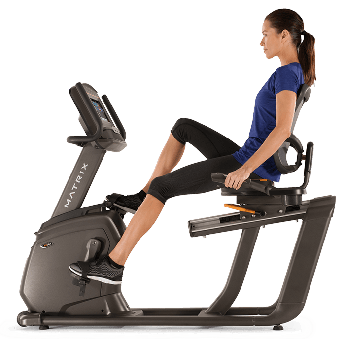young woman in blue sitting on the recumbent bike enjoying her exercise