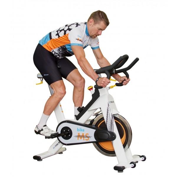 Man in fitness clothing riding a white, orange, and black exercise bike.