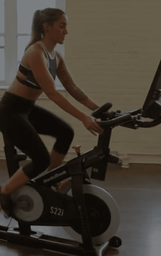 A woman riding an exercise bike.